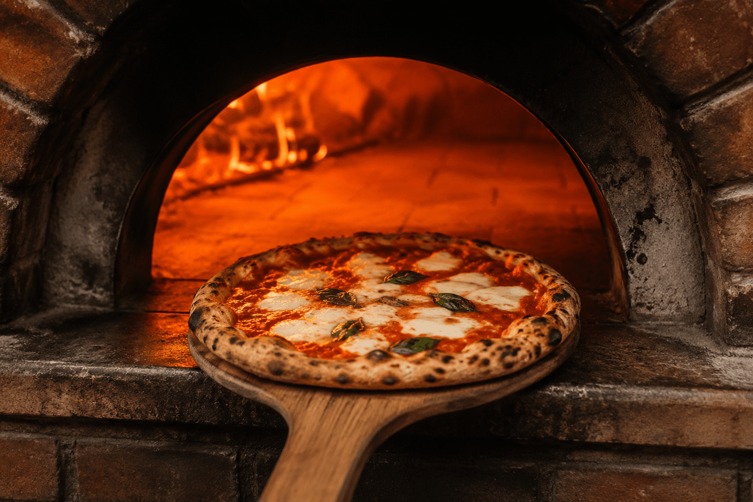 Four à bois traditionnel de la pizzeria, flammes visibles à l'intérieur